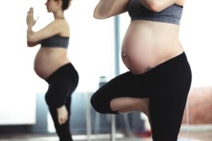 Pregnant woman in front of mirror doing yoga