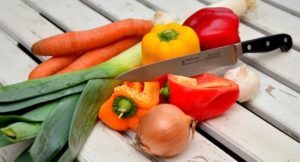 photo of carrots, leeks, peppers, onion, garlic and a chef knife