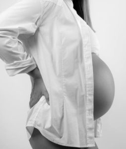 Pregnant woman holding her lower back