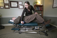 photo of a female doctor working with a male patient who is lying on his back