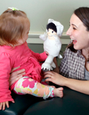 photo of female doctor entertaining baby with puppet